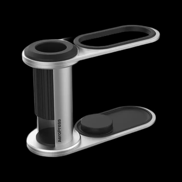 Metalowy organizer AeroPress – stojak na zaparzacz i akcesoria do AeroPressa, wykonany z aluminium i tworzywa, w kolorze srebrnym i czarnym, elegancki i kompaktowy design.