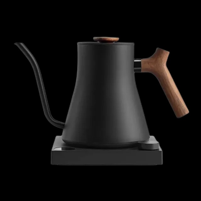 Czarny czajnik elektryczny Fellow Stagg EKG Pro z wąską szyjką typu gooseneck i elegancką drewnianą rączką, umieszczony na designerskiej podstawie.
