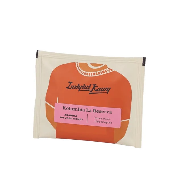 Drip bag z kawą Kolumbia La Reserva od Instytutu Kawy. Opakowanie z grafiką pomarańczowego swetra i różową etykietą. Profil smakowy: lychee, melon, białe winogrono. Arabika w obróbce infused honey.