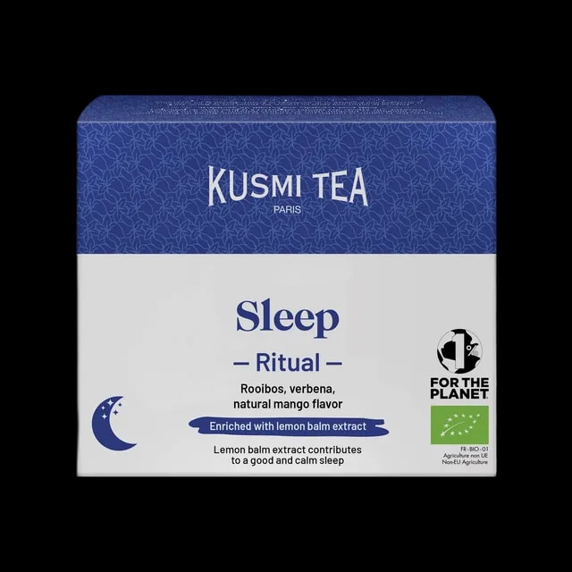 Opakowanie herbaty Kusmi Tea Sleep Ritual. Niebiesko-biała kolorystyka z widocznym logo Kusmi Tea Paris. Zawiera rooibos, werbenę oraz naturalny aromat mango, wzbogacone ekstraktem z melisy. Produkt ekologiczny z certyfikatem organicznym, wspierający spokojny sen. Widoczny symbol „1% for the planet.”