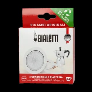 Zdjęcie zestawu uszczelek i sitek do kawiarek aluminiowych Bialetti 3-4 tz. Opakowanie zawiera trzy uszczelki gumowe i jedno sitko filtrujące, które są przedstawione na białym tle. Opakowanie w czerwono-białej kolorystyce z logotypem Bialetti oraz informacją o zawartości zestawu. Idealne do wymiany zużytych części w kawiarce, zapewniając długotrwałą jakość i doskonały smak kawy. Produkt ekologiczny, opakowanie w 100% nadające się do recyklingu.