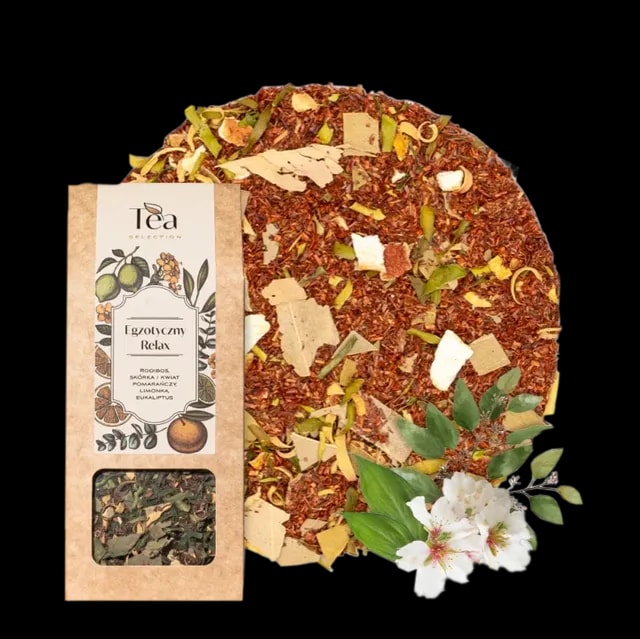 Herbata rooibos Egzotyczny Relax w ekologicznym opakowaniu, z dodatkiem skórki i kwiatu pomarańczy, limonki i eukaliptusa na tle białej miski wypełnionej herbatą. Obok leżą liście i kwiaty eukaliptusa.