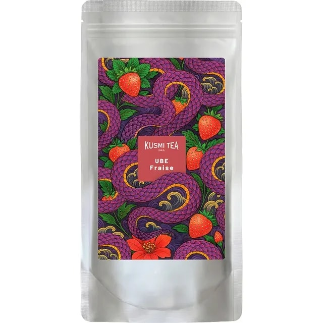 Opakowanie herbaty Kusmi Tea Ube Fraise zdobi kolorowy wzór z owocami i wężami. To wyjątkowa mieszanka smakowa, która łączy aromat ube z soczystymi truskawkami, idealna dla miłośników herbaty owocowej.